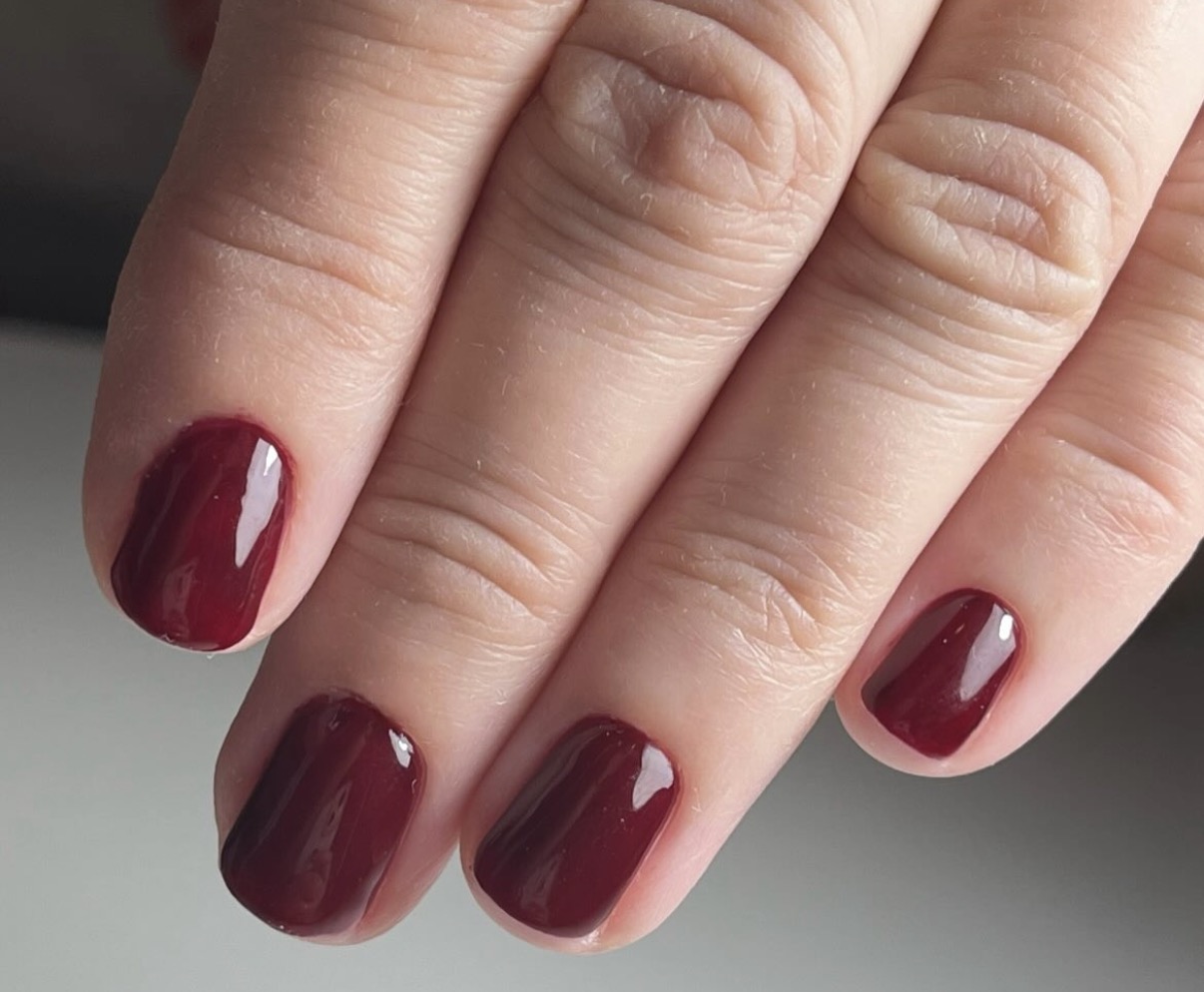 Tamnocrveni manikir na kratkim noktima.